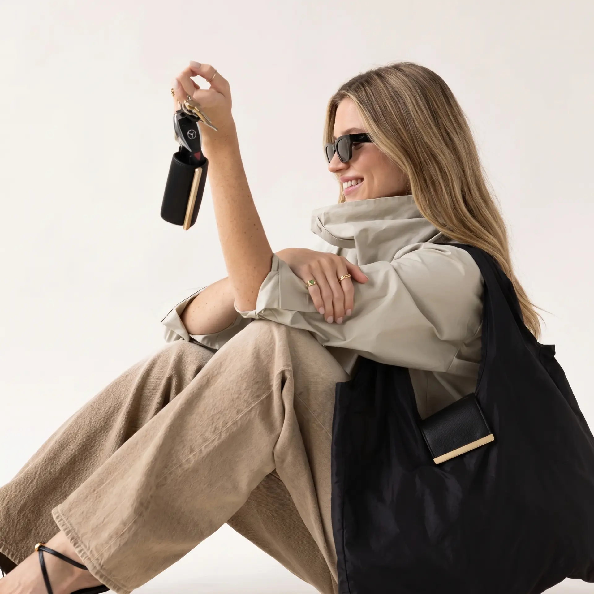 Woman holding the clipped cliptote pouch with a full tote over her shoulder
